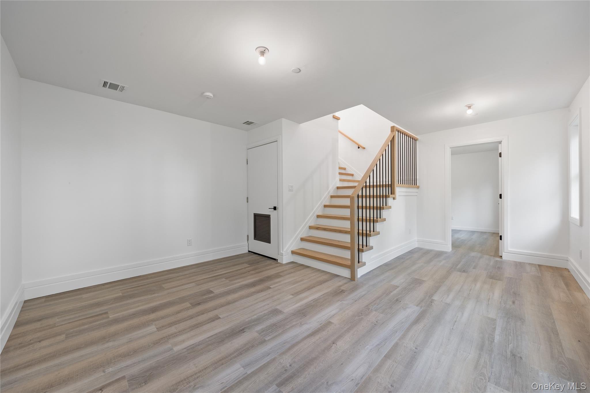 40 Singer Avenue, Unit 214 Spring Valley, NY 10977 - Photo 36 of 49 an empty room with wooden floor and white walls