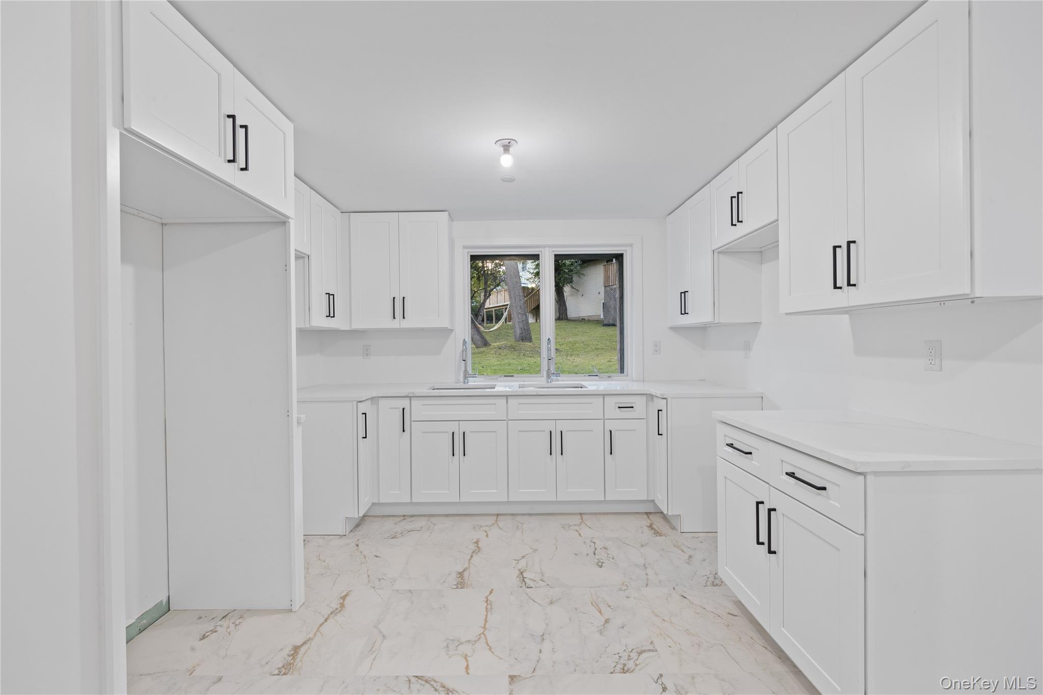 40 Singer Avenue, Unit 214 Spring Valley, NY 10977 - Photo 39 of 49 a kitchen with white cabinets and white appliances