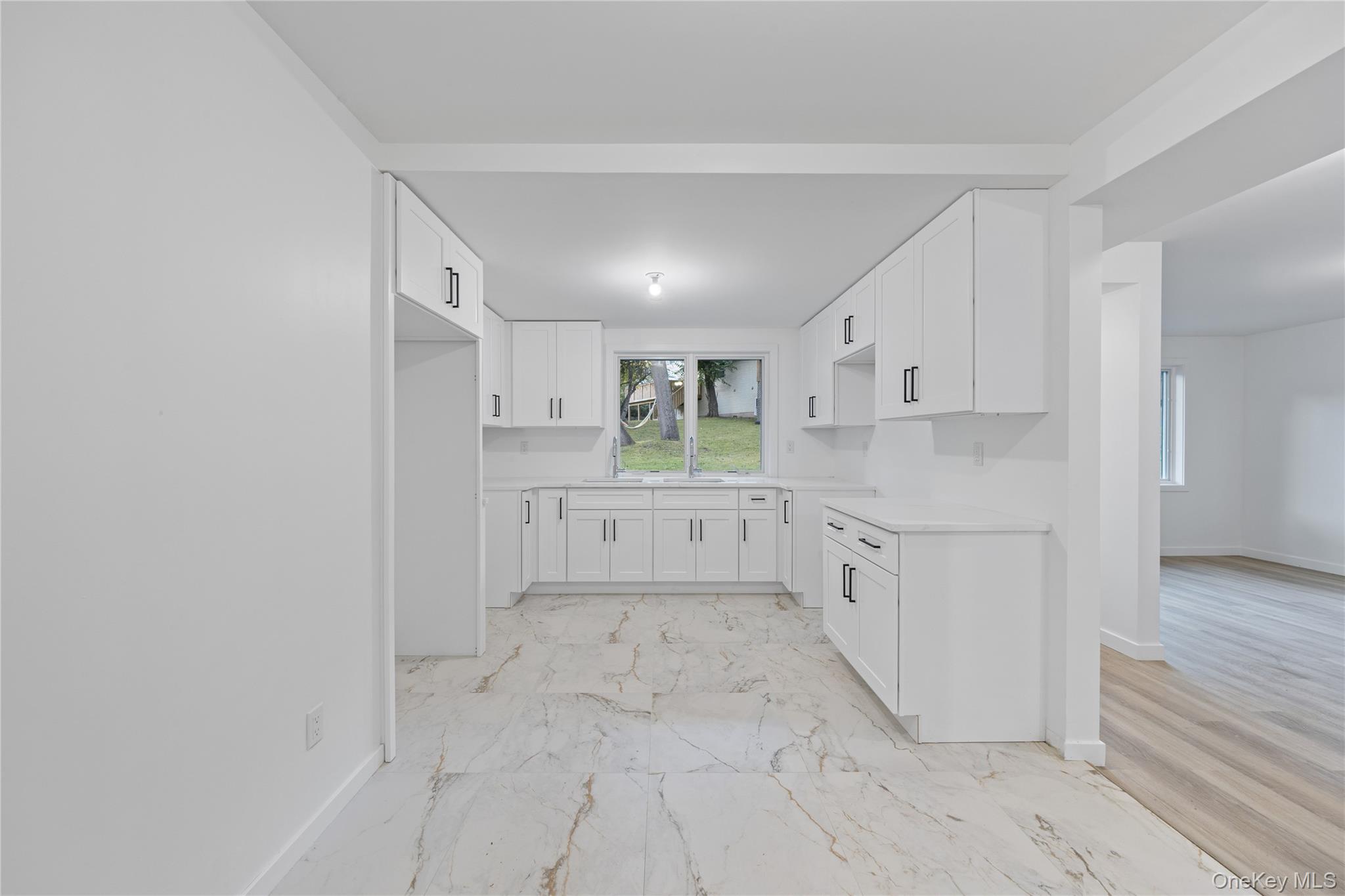 40 Singer Avenue, Unit 214 Spring Valley, NY 10977 - Photo 40 of 49 a large white kitchen with white cabinets