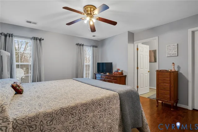 a bedroom with a bed a dresser and flat screen tv