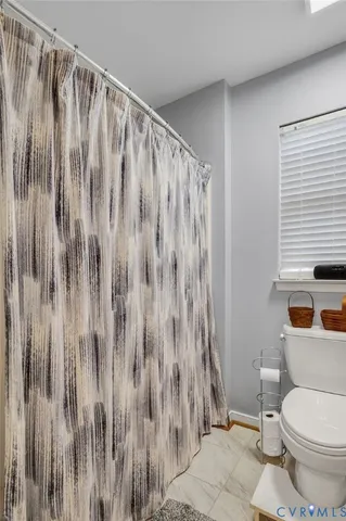 a white toilet sitting next to a shower curtain