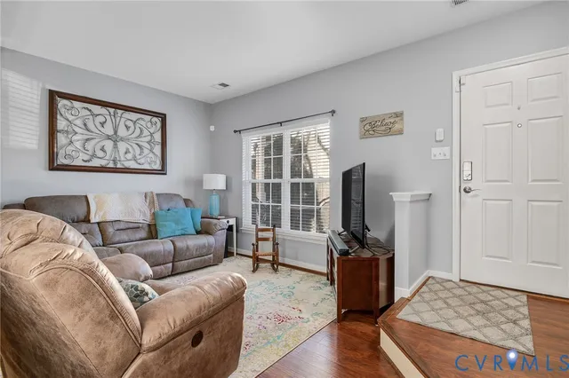 a living room with furniture tv and wooden floor