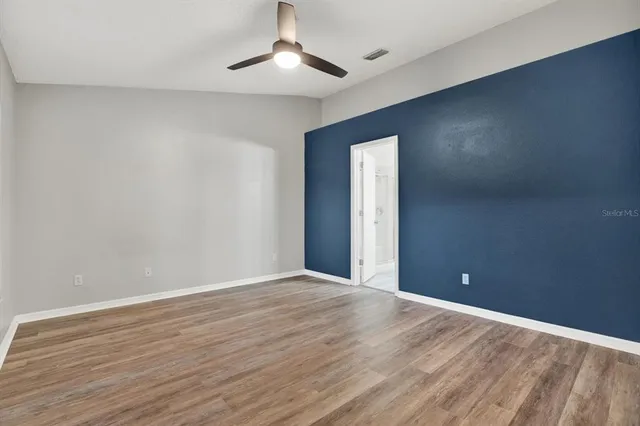 a view of an empty room with wooden floor