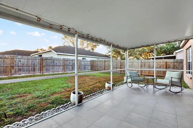 a view of a chairs and table in the back yard of the house