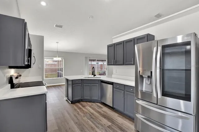 a kitchen with stainless steel appliances granite countertop a refrigerator and a sink