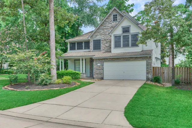 a front view of a house with a yard and trees