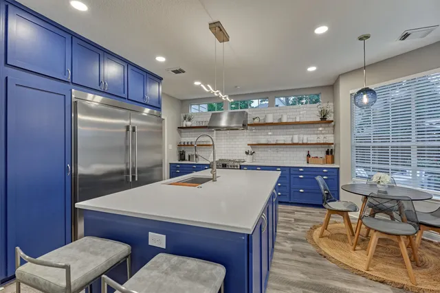 a kitchen with a table chairs refrigerator and cabinets