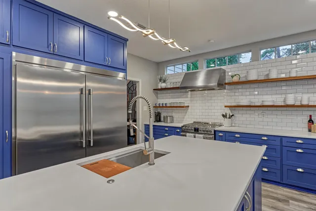 a kitchen with stainless steel appliances granite countertop a refrigerator and a sink