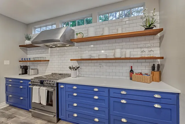 a kitchen with stainless steel appliances granite countertop a stove and a wooden cabinets