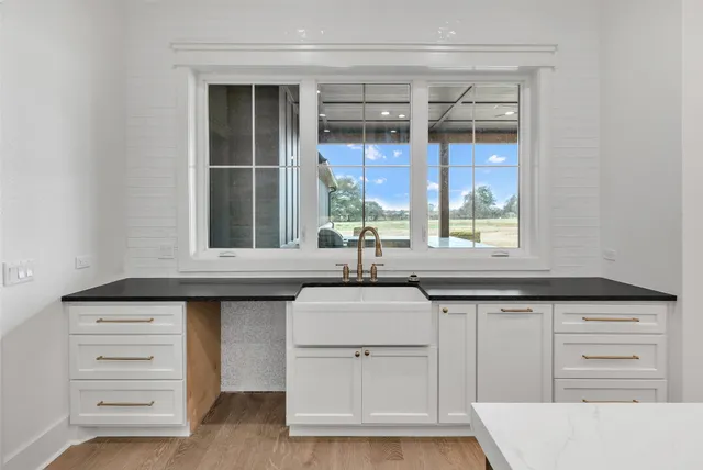 a kitchen with granite countertop a sink cabinets and window