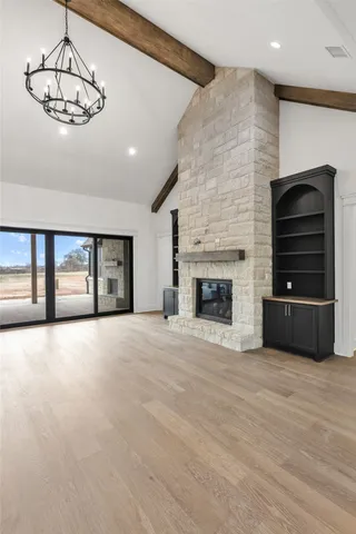a view of an empty room with a fireplace and window