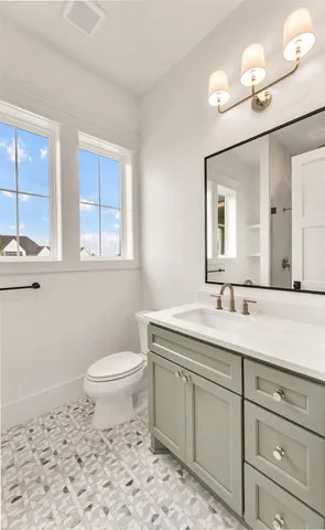 a bathroom with a toilet sink and mirror
