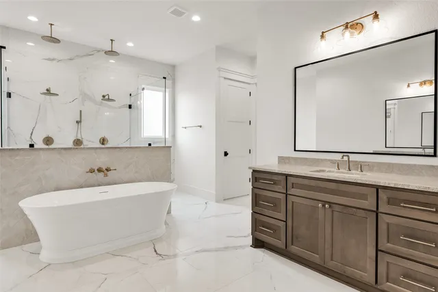 a bathroom with a double vanity sink large mirror and a bathtub