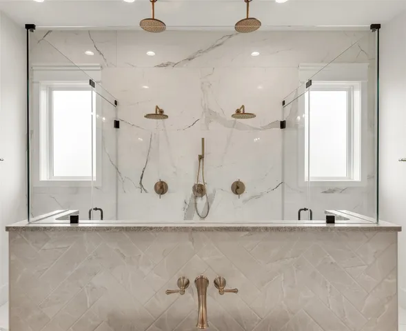 a bathroom with a tub a mirror and a shower