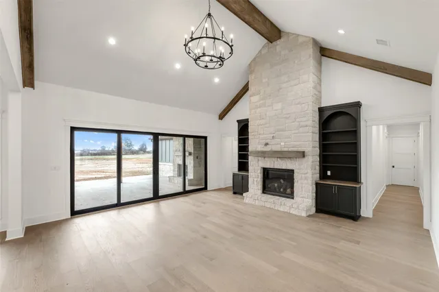 an empty room with windows and fireplace