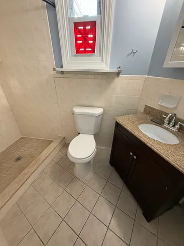 a bathroom with a granite countertop toilet sink and mirror