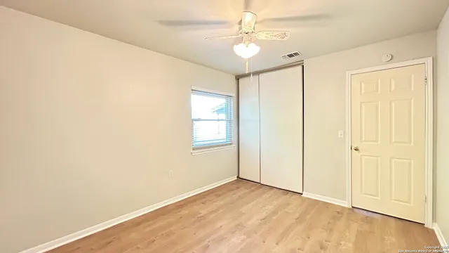 a view of an empty room with wooden floor