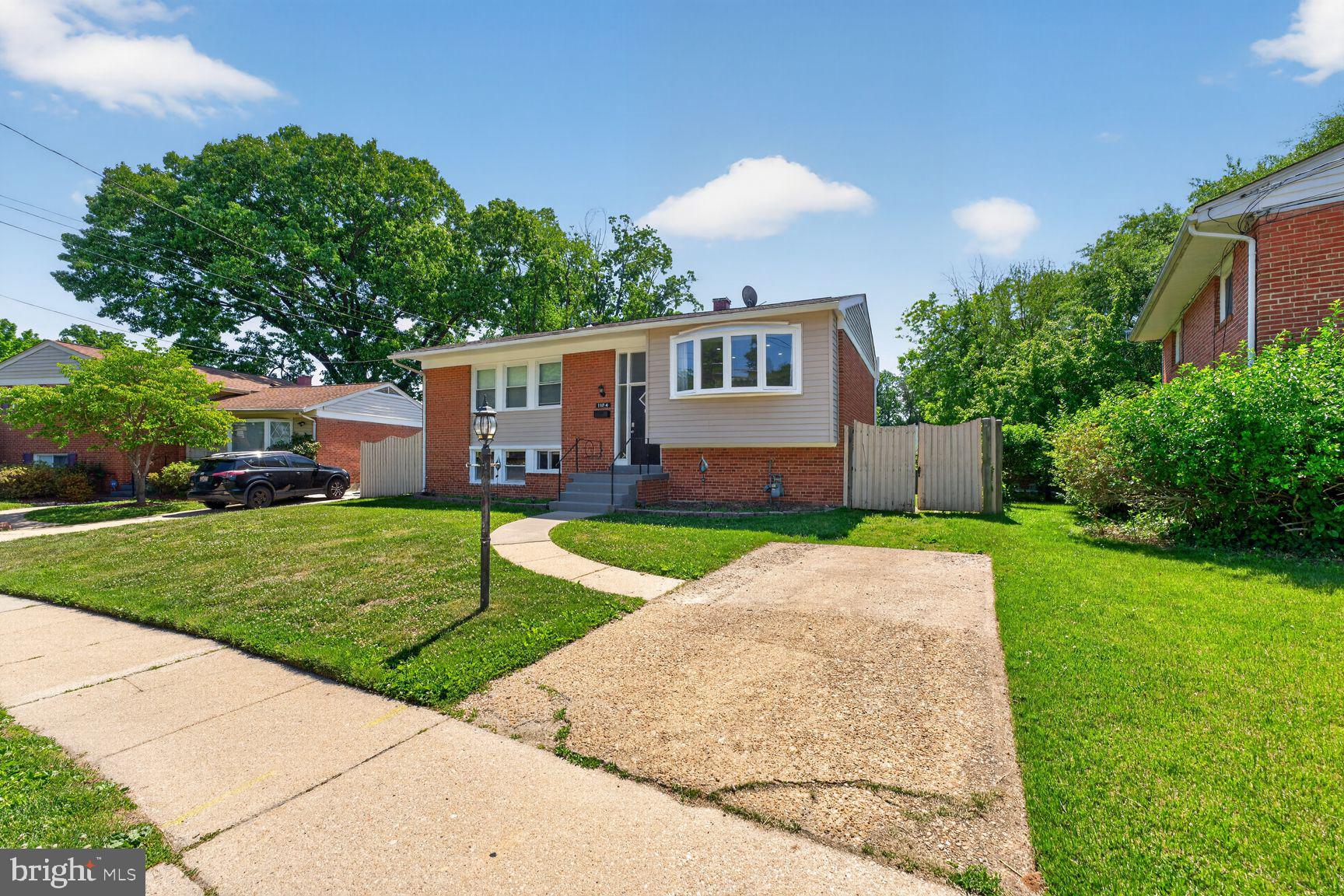 1104 Caddington Avenue Silver Spring, MD 20901 - Photo 32 of 35 a front view of a house with a yard and garage