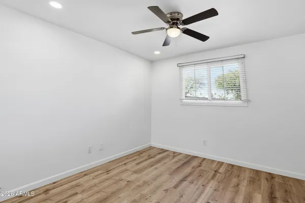 an empty room with closet and a ceiling fan