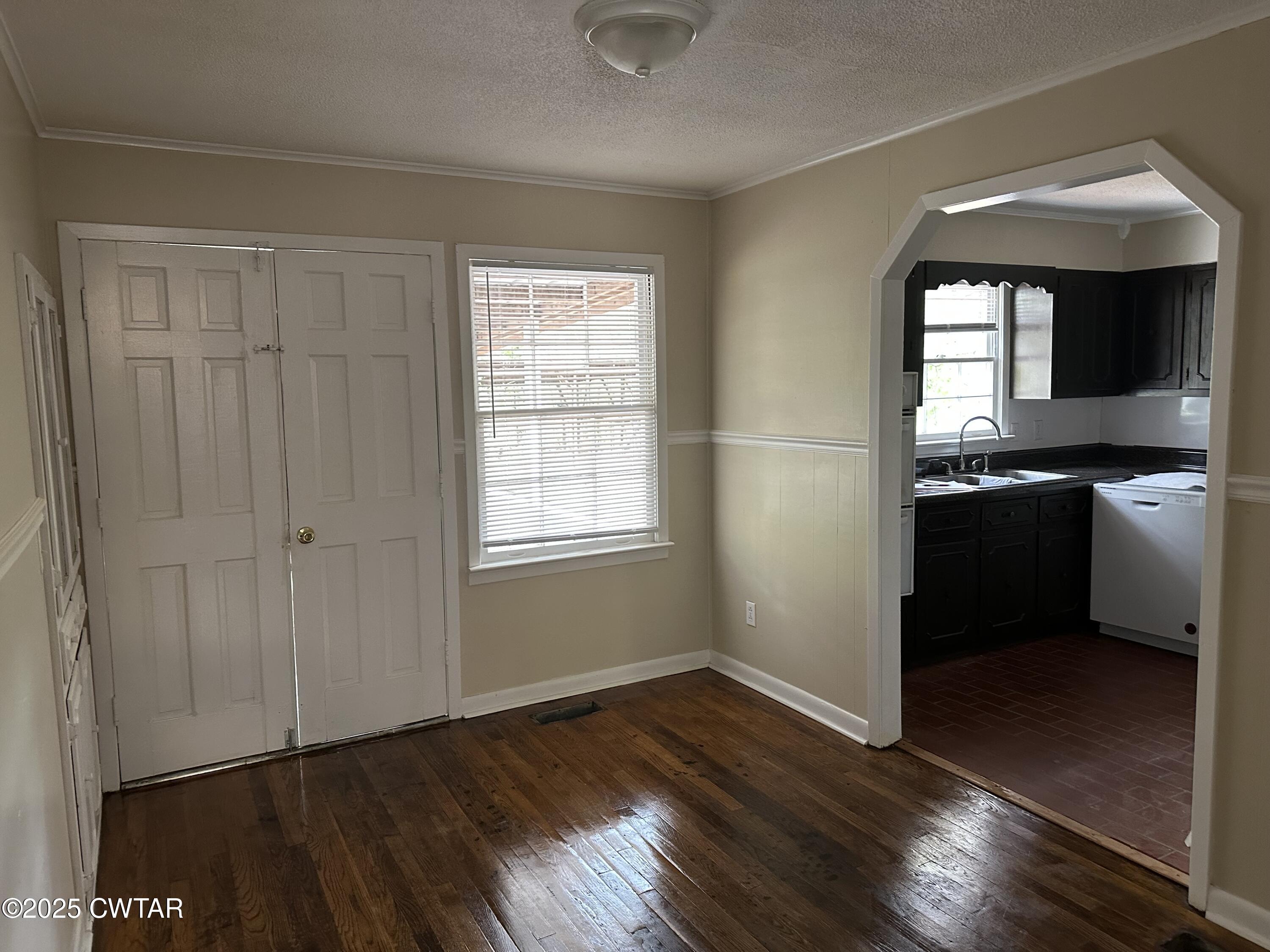 2400 Peddy Vestal Loop Henderson, TN 38340 - Photo 9 of 40 a view of a kitchen and an empty room with wooden floor and a window