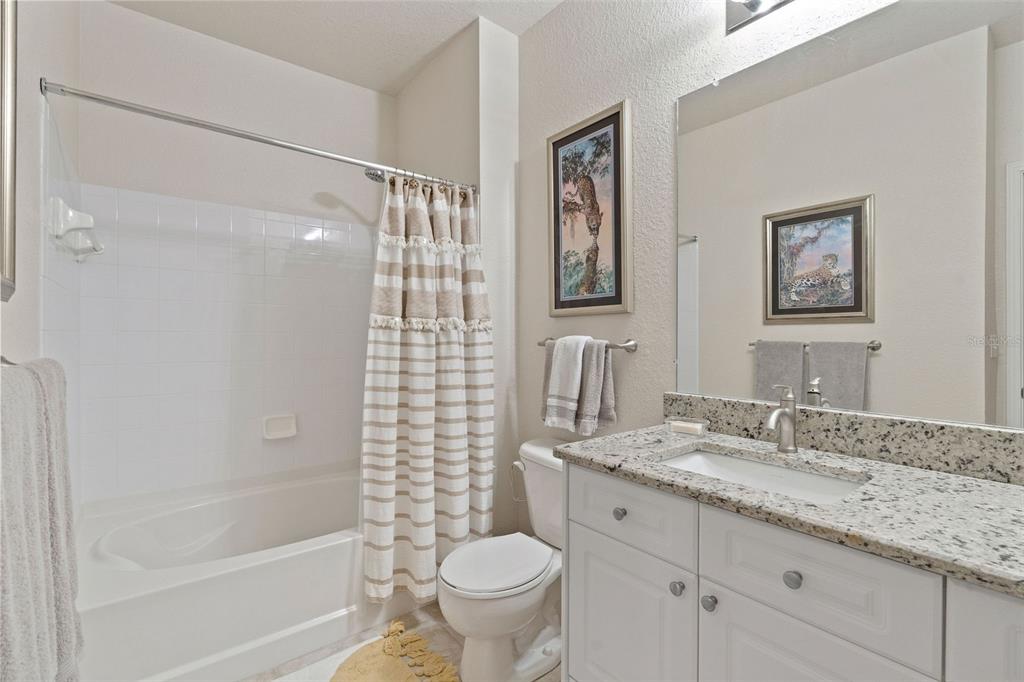 1216 South Missouri Avenue, Unit 419 Clearwater, FL 33756 - Photo 13 of 22 a bathroom with a granite countertop sink a toilet and a bathtub