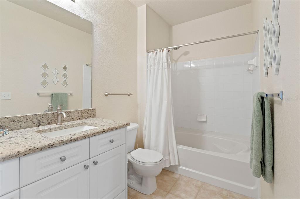 1216 South Missouri Avenue, Unit 419 Clearwater, FL 33756 - Photo 16 of 22 a bathroom with a granite countertop sink toilet and shower