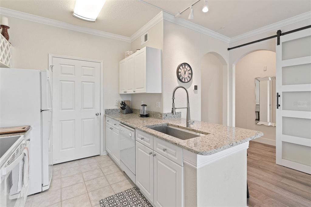 1216 South Missouri Avenue, Unit 419 Clearwater, FL 33756 - Photo 7 of 22 a kitchen with granite countertop white cabinets and sink