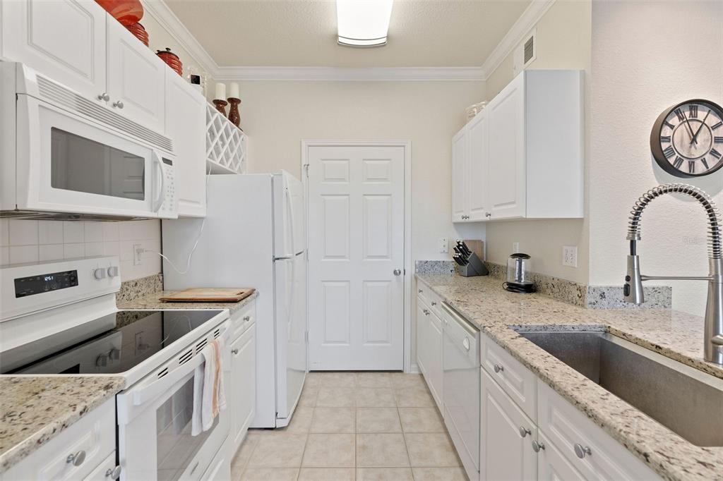 1216 South Missouri Avenue, Unit 419 Clearwater, FL 33756 - Photo 8 of 22 a kitchen with stainless steel appliances granite countertop a sink stove and refrigerator