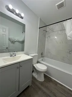a bathroom with a sink toilet a mirror and shower