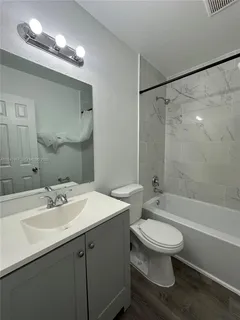 a bathroom with a sink toilet a mirror and shower