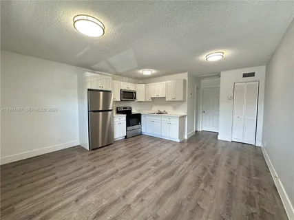 a kitchen with stainless steel appliances granite countertop a refrigerator and a stove top oven
