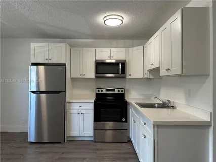 a kitchen with a sink a stove and refrigerator