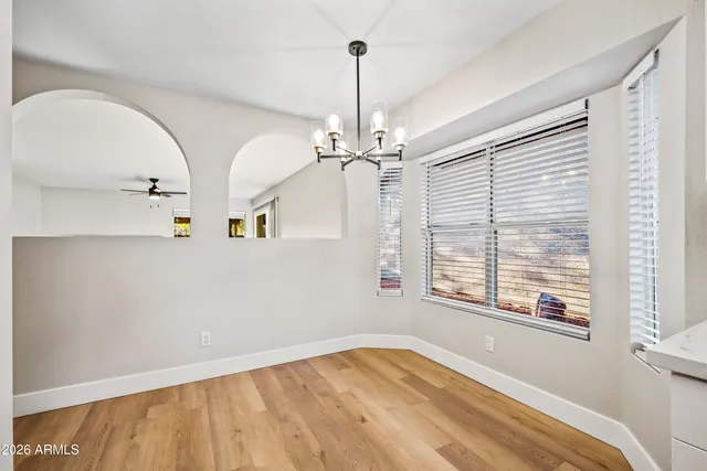 a view of a room with wooden floor and chandelier