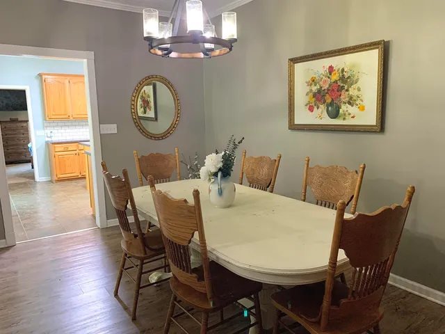 a view of a dining room with furniture a chandelier and wooden floor