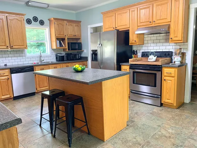 a kitchen with stainless steel appliances granite countertop a stove a refrigerator and a microwave