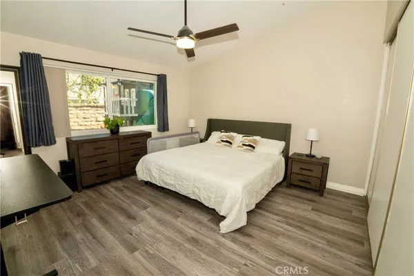 a bedroom with a bed a flat screen tv and a large window