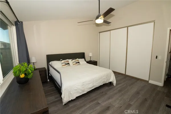 a bedroom with a bed a chandelier and a potted plant