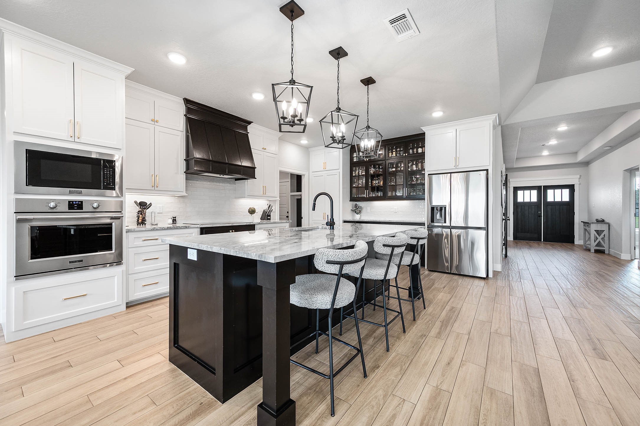 800 Greystone Lane Angleton, TX 77515 - Photo 14 of 49 a kitchen with stainless steel appliances a kitchen island hardwood floor sink stove dining table and chairs