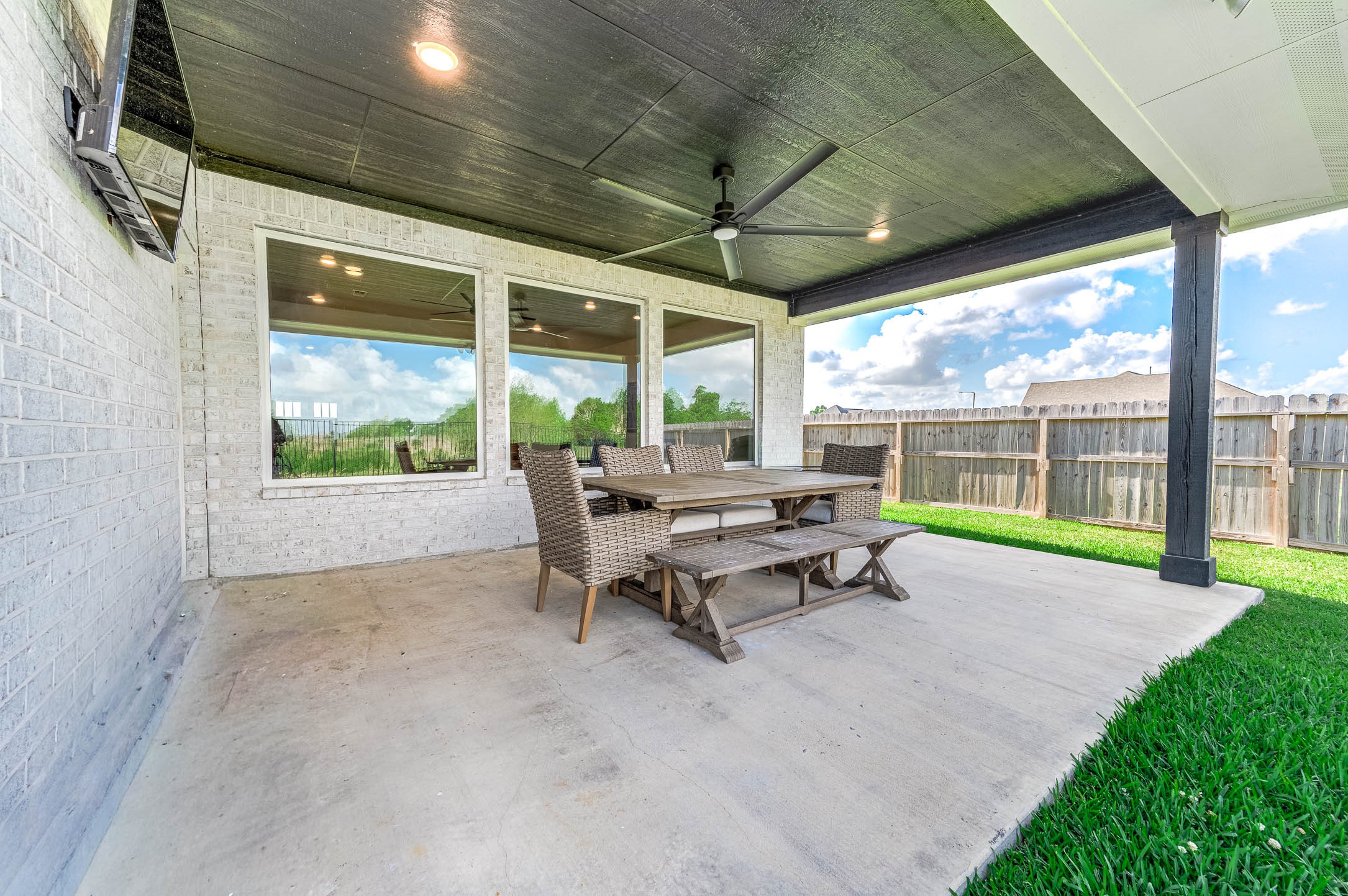 800 Greystone Lane Angleton, TX 77515 - Photo 43 of 49 a view of a patio with table and chairs under an umbrella with a big yard