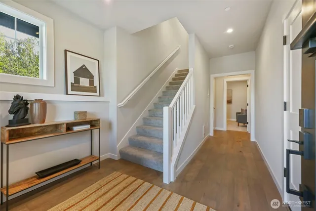 a view of a hallway with wooden floor and staircase