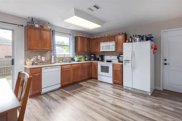 a kitchen with stainless steel appliances granite countertop a refrigerator sink and wooden floor