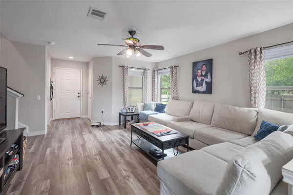 a living room with furniture a ceiling fan and a window