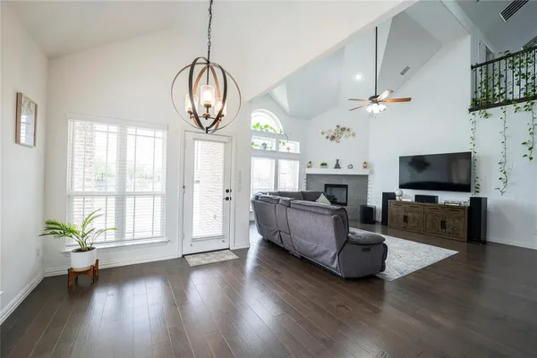 a living room with furniture chandelier and a flat screen tv