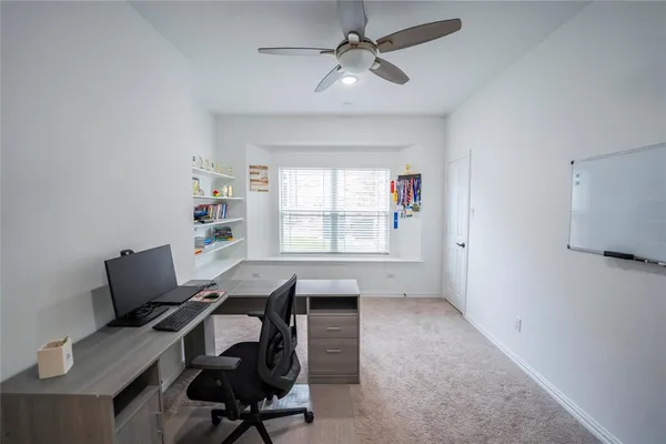 a view of a workspace with furniture and a window