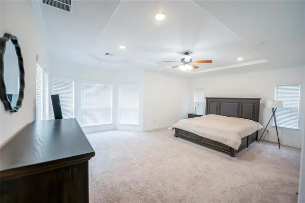 a spacious bedroom with a bed and a flat screen television