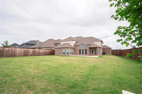 a view of a big house with a big yard and large trees