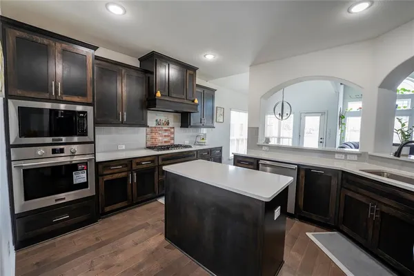 a kitchen with stainless steel appliances granite countertop a sink stove oven and refrigerator