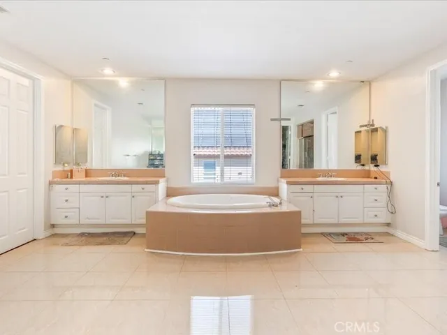 a large white kitchen with kitchen island a sink a stove and a refrigerator