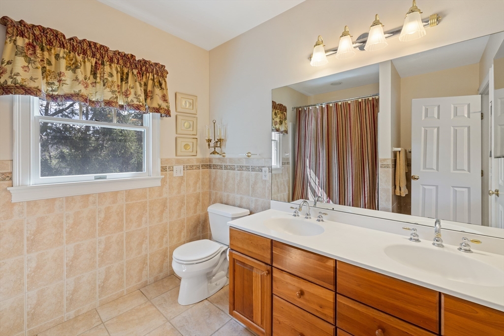 2 Marlboro Road Lexington, MA 02421 - Photo 23 of 36 a bathroom with a granite countertop sink mirror a toilet and a shower