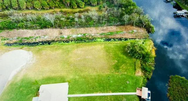 a view of a lake with a yard and potted plants